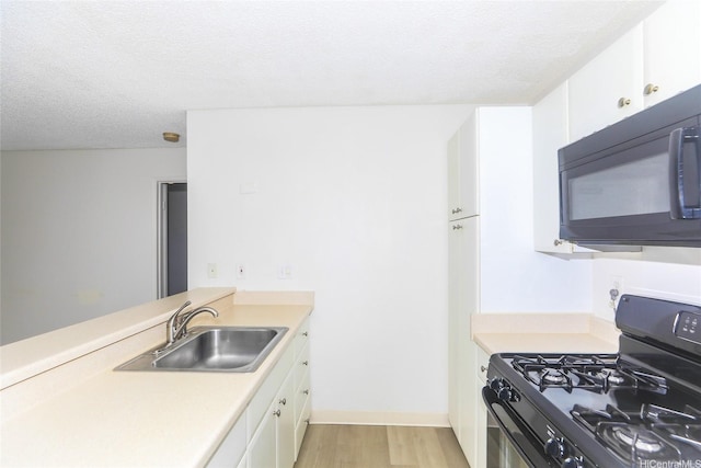 91-233 Hanapouli Cir Unit 29C, Ewa Beach, HI 96706 - kitchen featuring black appliances, a sink, light wood finished floors, light countertops, and a textured ceiling