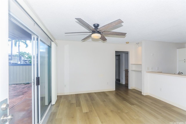 91-233 Hanapouli Cir Unit 29C, Ewa Beach, HI 96706 - spare room featuring light wood-style floors, ceiling fan, a textured ceiling, and baseboards
