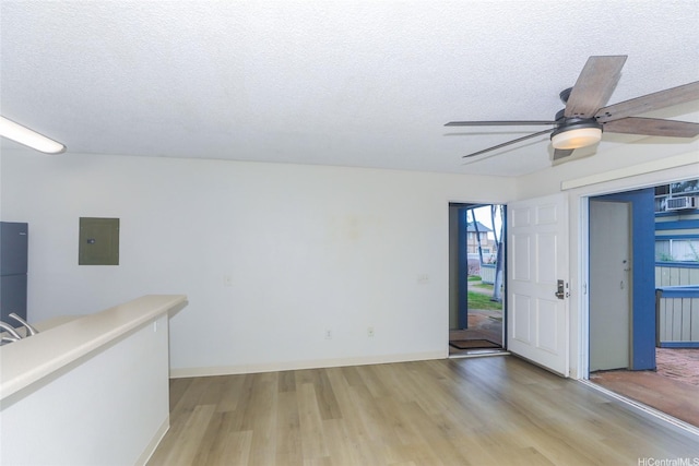 91-233 Hanapouli Cir Unit 29C, Ewa Beach, HI 96706 - unfurnished room featuring electric panel, light wood-style floors, ceiling fan, a textured ceiling, and baseboards