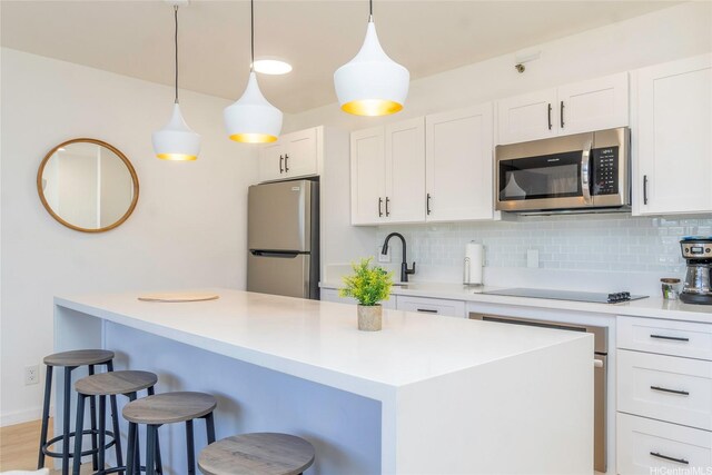 201 Ohua Ave Unit 2601-2, Honolulu, HI 96815 - kitchen with stainless steel appliances, a kitchen bar, tasteful backsplash, white cabinets, and a center island