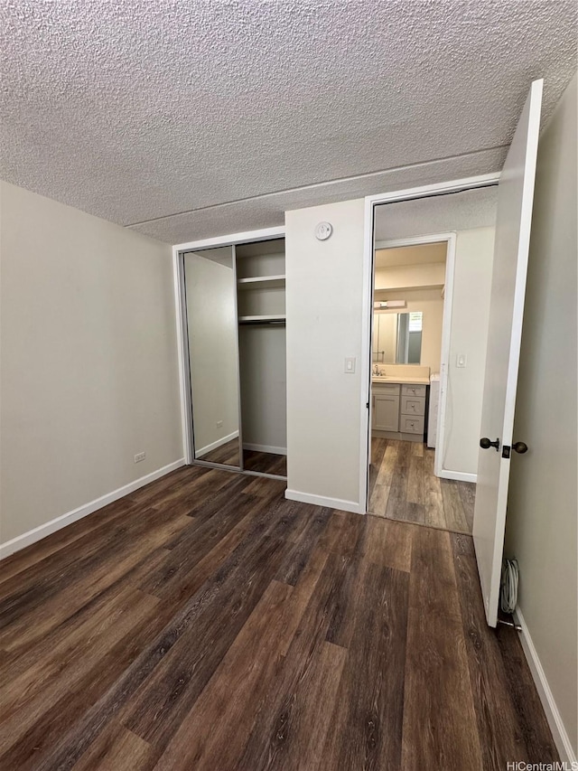 1717 Ala Wai Blvd Unit 501, Honolulu, HI 96815 - unfurnished bedroom with dark wood-style floors, a textured ceiling, a closet, and baseboards