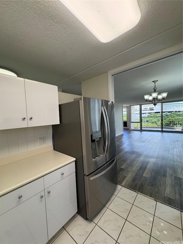 1717 Ala Wai Blvd Unit 501, Honolulu, HI 96815 - kitchen featuring white cabinets, stainless steel fridge, light countertops, a chandelier, and a textured ceiling