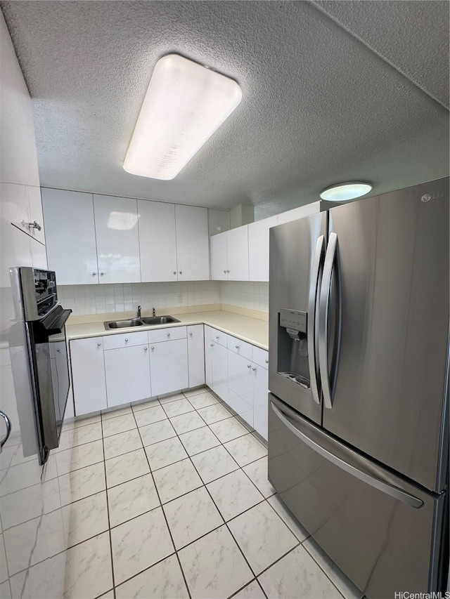 1717 Ala Wai Blvd Unit 501, Honolulu, HI 96815 - kitchen featuring stainless steel fridge, white cabinetry, light countertops, a textured ceiling, and decorative backsplash