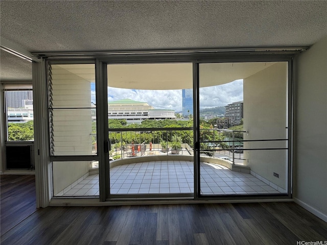 1717 Ala Wai Blvd Unit 501, Honolulu, HI 96815 - entryway with healthy amount of natural light, wood finished floors, a textured ceiling, baseboards, and a view of city