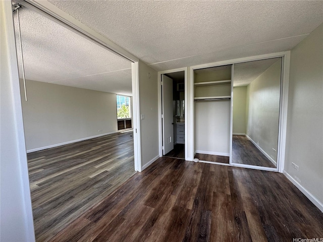 1717 Ala Wai Blvd Unit 501, Honolulu, HI 96815 - unfurnished bedroom featuring dark wood finished floors, a textured ceiling, a closet, and baseboards