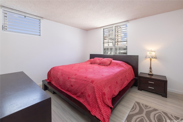 2233 Ala Wai Blvd Unit 10C, Honolulu, HI 96815 - bedroom with light wood finished floors and a textured ceiling