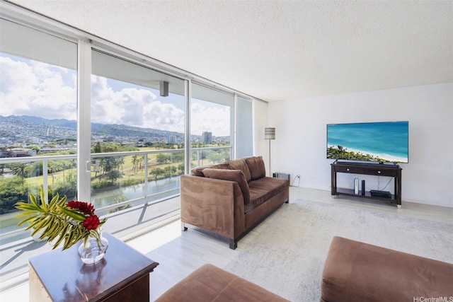 2233 Ala Wai Blvd Unit 10C, Honolulu, HI 96815 - living area with a textured ceiling, expansive windows, and light wood finished floors