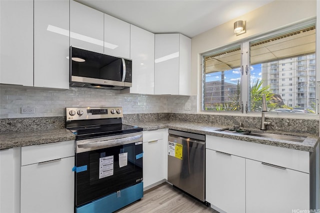 98-297 Ualo St Unit W1, Aiea, HI 96701 - kitchen featuring stainless steel appliances, a sink, white cabinets, light wood-style flooring, and healthy amount of natural light