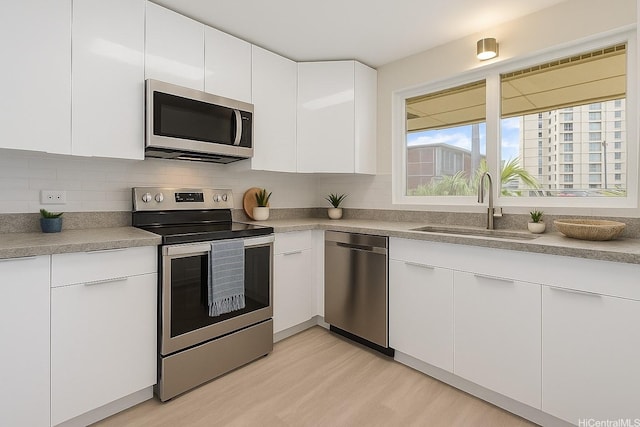 98-297 Ualo St Unit W1, Aiea, HI 96701 - kitchen with appliances with stainless steel finishes, a sink, light wood-type flooring, and white cabinets