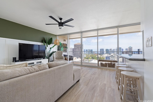1520 Ward Ave Unit 902, Honolulu, HI 96822 - living area with floor to ceiling windows, light wood-type flooring, and a ceiling fan