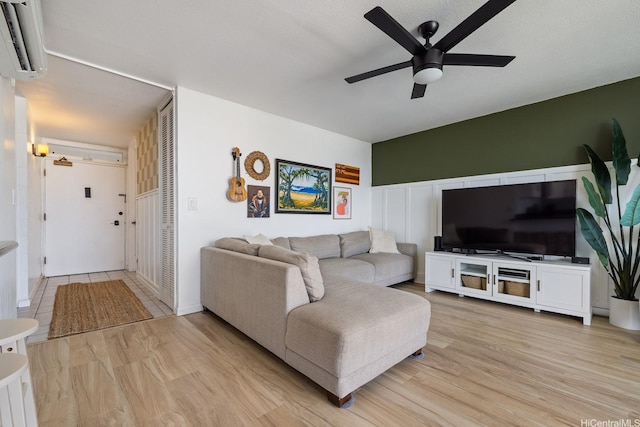1520 Ward Ave Unit 902, Honolulu, HI 96822 - living area featuring a wall mounted air conditioner, ceiling fan, light wood-style floors, and a decorative wall