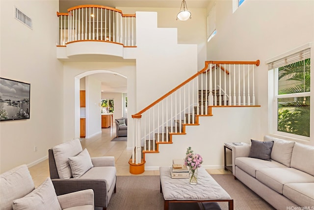 91-1019 Kai Uhu St, Ewa Beach, HI 96706 - living room with a high ceiling, arched walkways, light tile patterned floors, and stairs