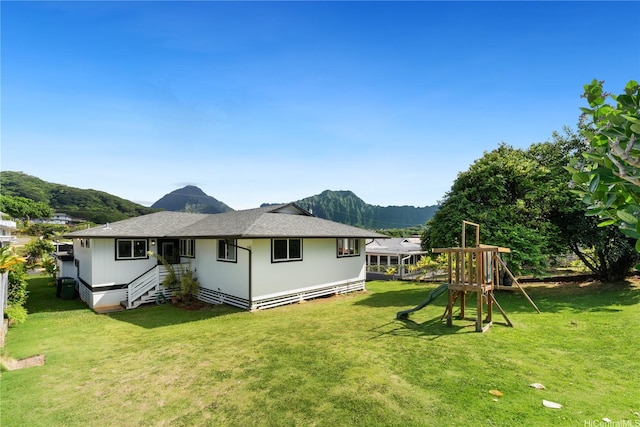 45-237 Popoki Pl, Kaneohe, HI 96744 - rear view of house with a playground, a lawn, a mountain view, and roof with shingles