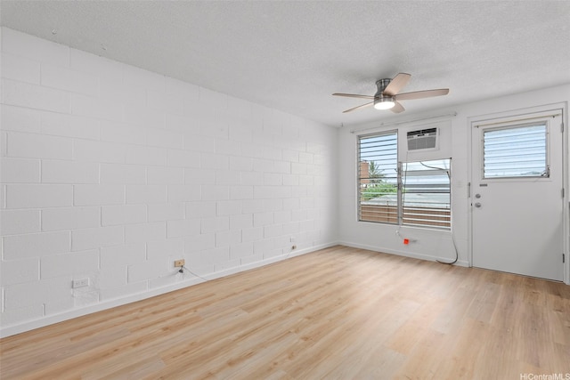 636 Nalanui St Unit 302, Honolulu, HI 96817 - unfurnished room featuring ceiling fan, a textured ceiling, light wood-style floors, a wall unit AC, and baseboards