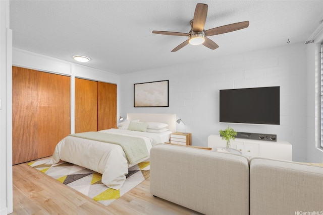 636 Nalanui St Unit 302, Honolulu, HI 96817 - bedroom featuring light wood-style floors, multiple closets, ceiling fan, and a textured ceiling