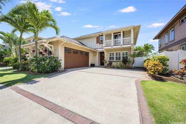 91-1099 Waikai St, Ewa Beach, HI 96706 - traditional-style house with a balcony, concrete driveway, an attached garage, board and batten siding, and stucco siding