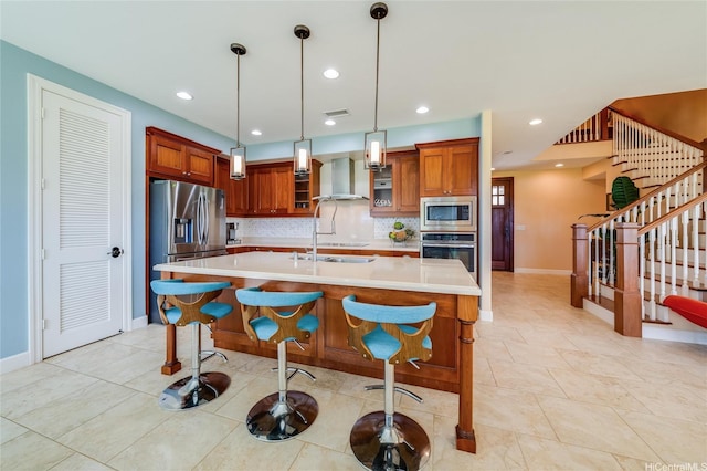 91-1099 Waikai St, Ewa Beach, HI 96706 - kitchen with stainless steel appliances, wall chimney range hood, light countertops, a kitchen island with sink, and backsplash