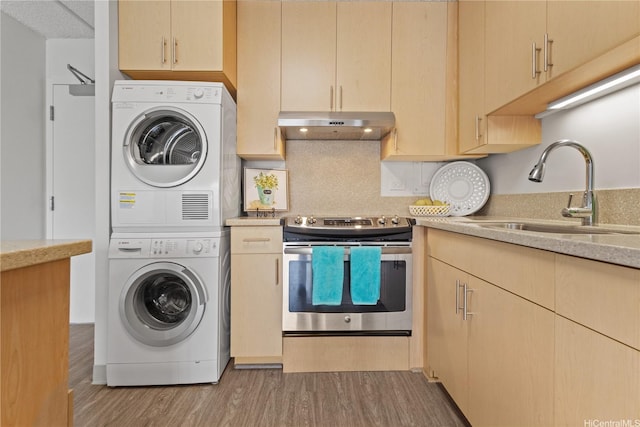 1333 Heulu St Unit 808, Honolulu, HI 96822 - kitchen featuring electric stove, stacked washer and clothes dryer, a sink, under cabinet range hood, and light wood-type flooring