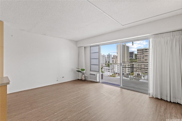 1333 Heulu St Unit 808, Honolulu, HI 96822 - empty room featuring a view of city, wood finished floors, and a textured ceiling