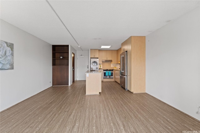 1333 Heulu St Unit 808, Honolulu, HI 96822 - kitchen with appliances with stainless steel finishes, wood finished floors, light countertops, a kitchen island with sink, and under cabinet range hood