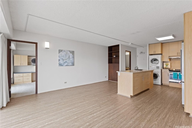 1333 Heulu St Unit 808, Honolulu, HI 96822 - kitchen featuring light wood-style floors, stainless steel range oven, a textured ceiling, light brown cabinetry, and stacked washer and clothes dryer