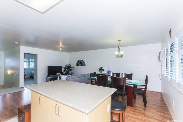 95-955 Ukuwai St Unit 1703, Mililani, HI 96789 - kitchen with a center island, light wood-style floors, a chandelier, and pendant lighting