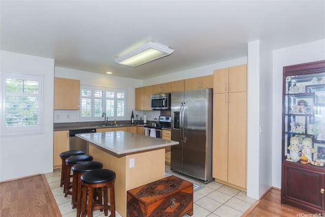 95-955 Ukuwai St Unit 1703, Mililani, HI 96789 - kitchen with appliances with stainless steel finishes, a sink, a kitchen island, a kitchen bar, and light wood-style floors