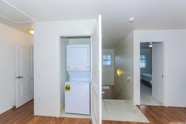 95-955 Ukuwai St Unit 1703, Mililani, HI 96789 - laundry room with stacked washer / drying machine, wood finished floors, and baseboards