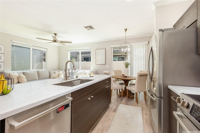 91-1160 Kamakana St Unit 609, Ewa Beach, HI 96706 - kitchen with stainless steel appliances, a sink, dark brown cabinets, light countertops, and light wood-style floors