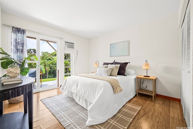 44-140-5MUIPL Mui Pl Unit 2705, Kaneohe, HI 96744 - bedroom featuring access to outside, wood finished floors, baseboards, a wall unit AC, and a closet