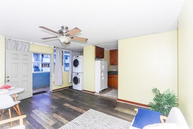 94-249 Waikele Rd Unit B209, Waipahu, HI 96797 - laundry area featuring estacked washer and dryer, dark wood-style flooring, ceiling fan, and baseboards