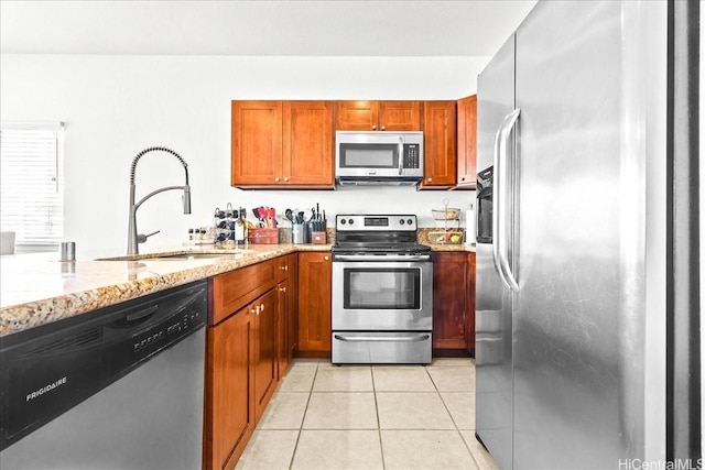87-176 Maipalaoa Rd Unit J24, Waianae, HI 96792 - kitchen with stainless steel appliances, a sink, light stone countertops, light tile patterned floors, and brown cabinets