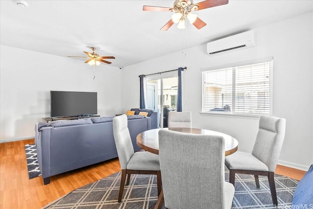 87-176 Maipalaoa Rd Unit J24, Waianae, HI 96792 - dining area featuring a ceiling fan, an AC wall unit, wood finished floors, and baseboards
