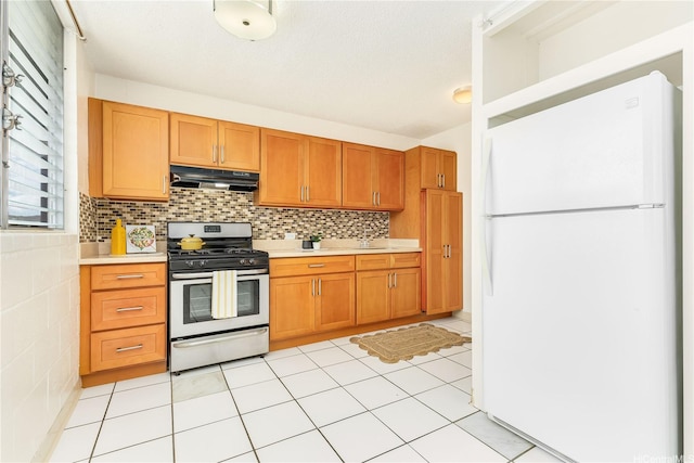 1519 Kaumualii St Unit 316, Honolulu, HI 96817 - kitchen featuring freestanding refrigerator, stainless steel gas range, under cabinet range hood, light countertops, and a sink