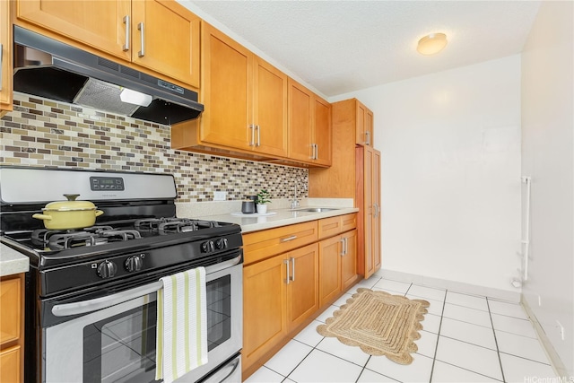 1519 Kaumualii St Unit 316, Honolulu, HI 96817 - kitchen with stainless steel range with gas cooktop, under cabinet range hood, light countertops, and decorative backsplash