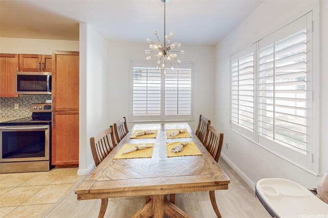 91-215 Keonekapu Pl, Ewa Beach, HI 96706 - dining room featuring a chandelier, plenty of natural light, light wood finished floors, and baseboards