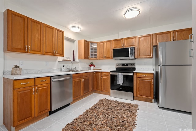 41-179 Nalu St, Waimanalo, HI 96795 - kitchen with appliances with stainless steel finishes, a sink, brown cabinets, and light tile patterned floors