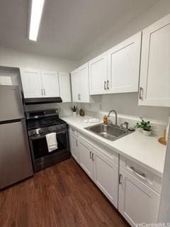 87-130 Helelua St Unit E102, Waianae, HI 96792 - kitchen with freestanding refrigerator, range with gas stovetop, white cabinetry, range hood, and light countertops