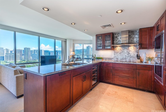 223 Saratoga Rd Unit 2203, Honolulu, HI 96815 - kitchen featuring black appliances, wall chimney exhaust hood, a sink, open floor plan, and a peninsula