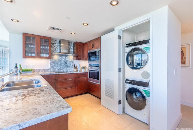223 Saratoga Rd Unit 2203, Honolulu, HI 96815 - kitchen with stainless steel oven, stacked washer and clothes dryer, wall chimney exhaust hood, built in microwave, and a sink