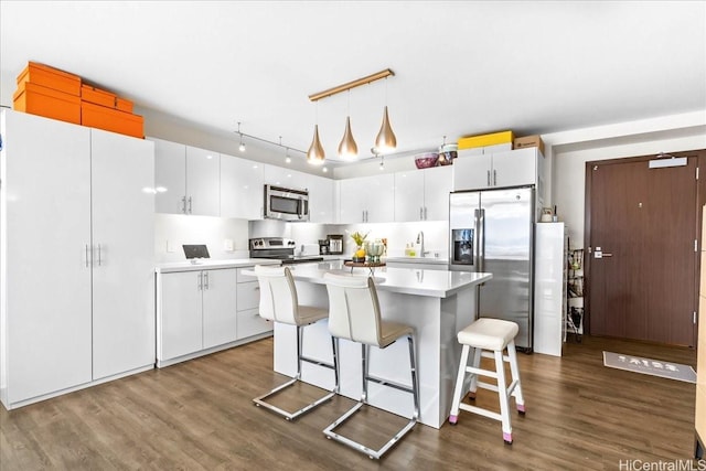 888 Kapiolani Blvd Unit 1512, Honolulu, HI 96813 - kitchen featuring appliances with stainless steel finishes, a kitchen island, dark wood finished floors, and light countertops