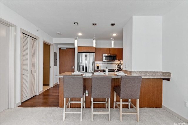 555 S St Unit 3003, Honolulu, HI 96813 - kitchen featuring appliances with stainless steel finishes, brown cabinetry, a peninsula, a breakfast bar, and recessed lighting