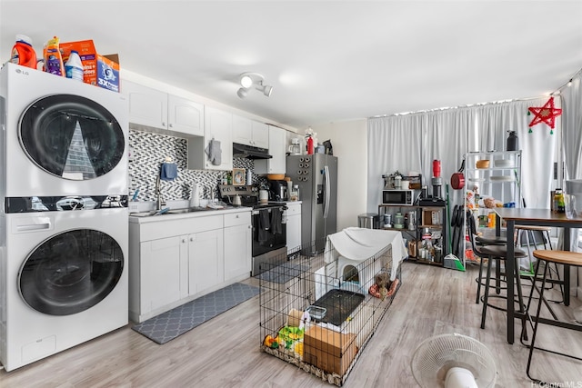 2421 Tusitala St Unit 803, Honolulu, HI 96815 - kitchen with appliances with stainless steel finishes, stacked washer / dryer, under cabinet range hood, and light wood-type flooring