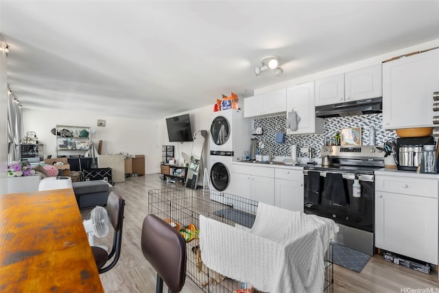 2421 Tusitala St Unit 803, Honolulu, HI 96815 - kitchen featuring electric range, under cabinet range hood, stacked washer / drying machine, light wood-type flooring, and tasteful backsplash