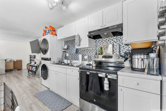 2421 Tusitala St Unit 803, Honolulu, HI 96815 - kitchen featuring electric range, stacked washer / dryer, under cabinet range hood, a sink, and backsplash