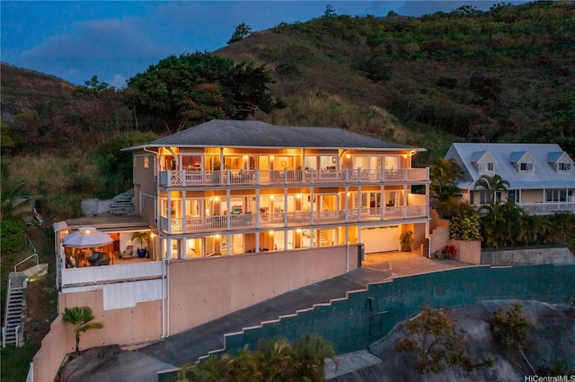 44-097 Kalenakai Pl, Kaneohe, HI 96744 - back of house with a balcony, an attached garage, a mountain view, and driveway