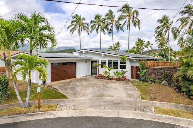 880 Akiu Pl, Kailua, HI 96734 - view of front of house with an attached garage, driveway, and roof mounted solar panels