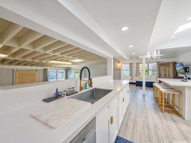 67-342 Kukea Cir, Waialua, HI 96791 - kitchen with a sink, white cabinetry, light wood-style floors, a breakfast bar, and light countertops