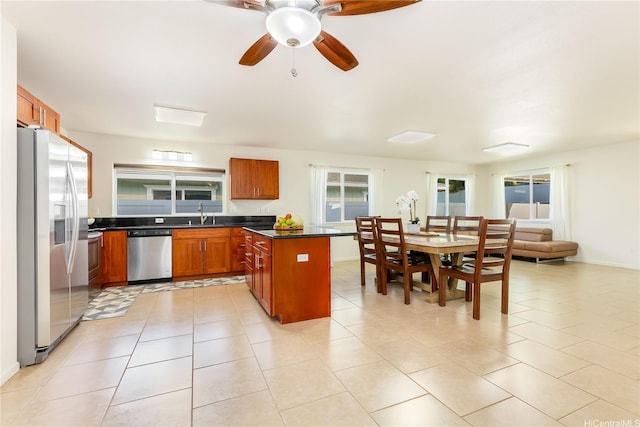 84-575 Kili Dr Unit 53, Waianae, HI 96792 - kitchen featuring stainless steel appliances, dark countertops, ceiling fan, brown cabinets, and light tile patterned flooring