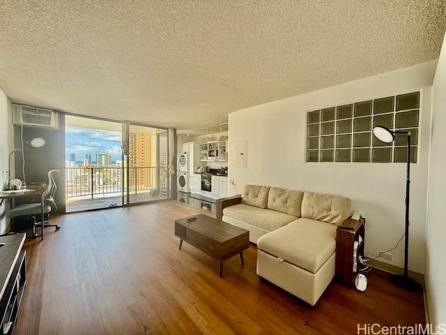 1630 Liholiho St Unit 2001, Honolulu, HI 96822 - living area featuring a textured ceiling, wood finished floors, floor to ceiling windows, and a wall mounted AC
